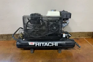 Black Hitachi gas air compressor on display indoors.