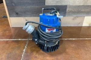 Submersible pump with blue top and black base on brown tiled floor