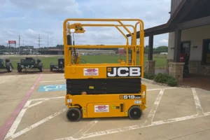 JCB 19ft yellow scissor lift parked on a designated spot outside a commercial building
