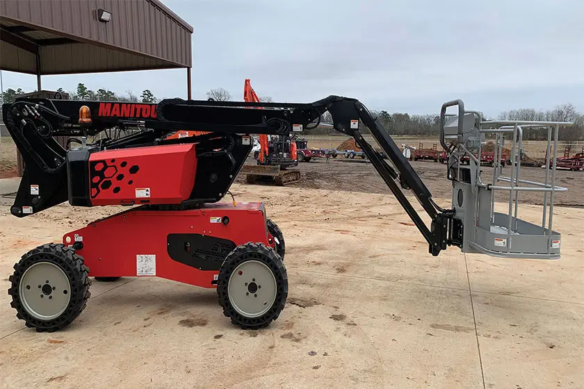 Fully extended Manitou manlift with an attached basket showcased in an open field