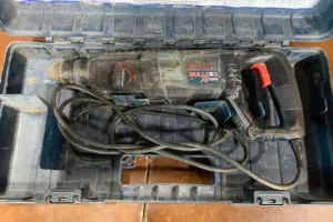 Bosch Bulldog Xtreme hammer drill with case and accessories, visibly used.