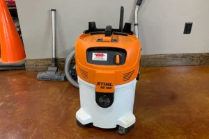 Stihl SE 122 wet/dry shop vacuum with an orange and white design on a brown floor