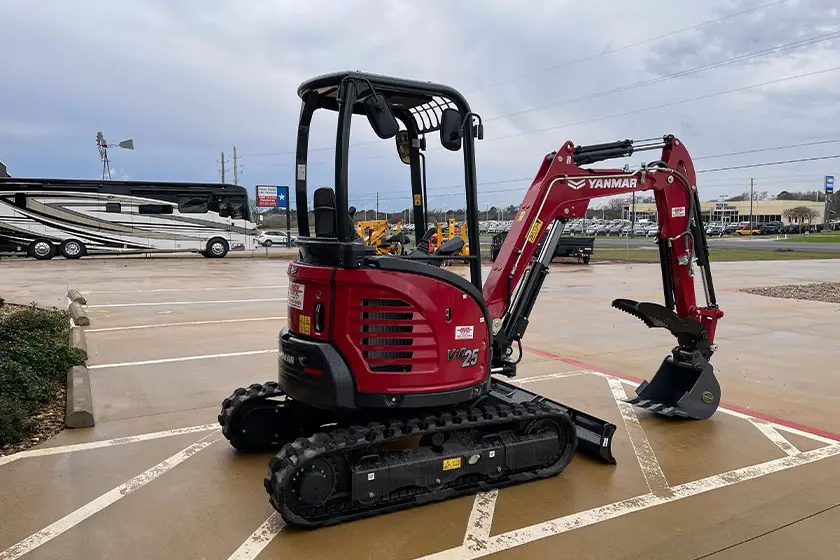 Yanmar VIO 25 compact excavator with red and black design in a parking lot